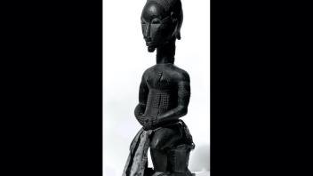 Seated female wood figurine with scarification markings.