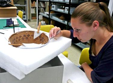 museum intern Katherine Dixon repairing ethnographic basket for conservation